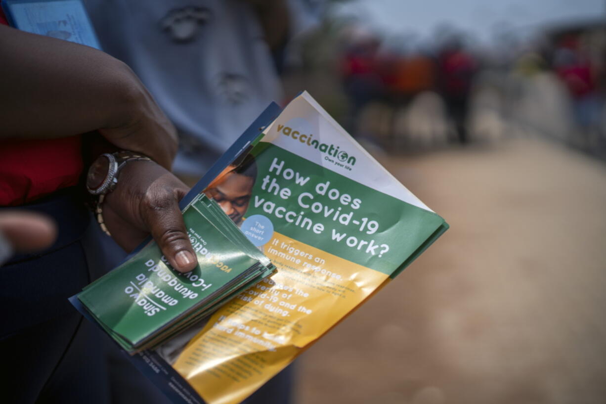 Volunteers go door to door with vaccination information material in Lawley, South Africa, during a visit of local government officials for the launch of the Vooma vaccination program against COVID-19 Friday Dec. 3, 2021. South Africa has accelerated its vaccination campaign a week after the discovery of the omicron variant of the coronavirus.