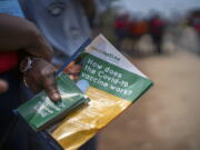 Volunteers go door to door with vaccination information material in Lawley, South Africa, during a visit of local government officials for the launch of the Vooma vaccination program against COVID-19 Friday Dec. 3, 2021. South Africa has accelerated its vaccination campaign a week after the discovery of the omicron variant of the coronavirus.