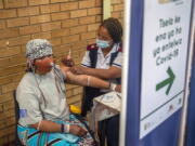 An Orange Farm, South Africa, resident receives her jab against COVID-19 Friday Dec. 3, 2021 at the Orange Farm multipurpose center. South Africa has accelerated its vaccination campaign a week after the discovery of the omicron variant of the coronavirus.