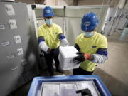 FILE - Boxes containing the Pfizer COVID-19 vaccine are prepared to be shipped at the Pfizer Global Supply Kalamazoo manufacturing plant in Portage, Mich., Dec. 13, 2020. The nation's COVID-19 death toll stands at around 800,000 as the anniversary of the U.S. vaccine rollout arrives. A year ago it stood at 300,000. What might have been a time to celebrate a scientific achievement is fraught with discord and mourning.