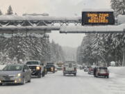 Heavy traffic is seen at the base of a snowy Santiam Pass in Detroit, Ore., Sunday, Dec. 26, 2021. Emergency warming shelters were opened throughout western Washington and Oregon as temperatures plunged into the teens and lower and forecasters said the arctic blast would last for several days.