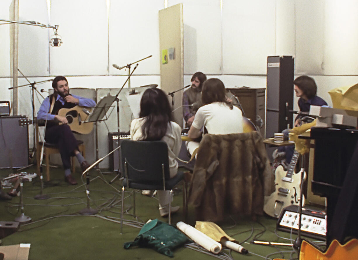 This image released by Disney+ shows, background from left, Paul McCartney, Ringo Starr and George Harrison, and foreground from left, Yoko Ono and John Lennon in a scene from the nearly eight-hour Peter Jackson-produced documentary "Get Back." (Disney+ via AP)