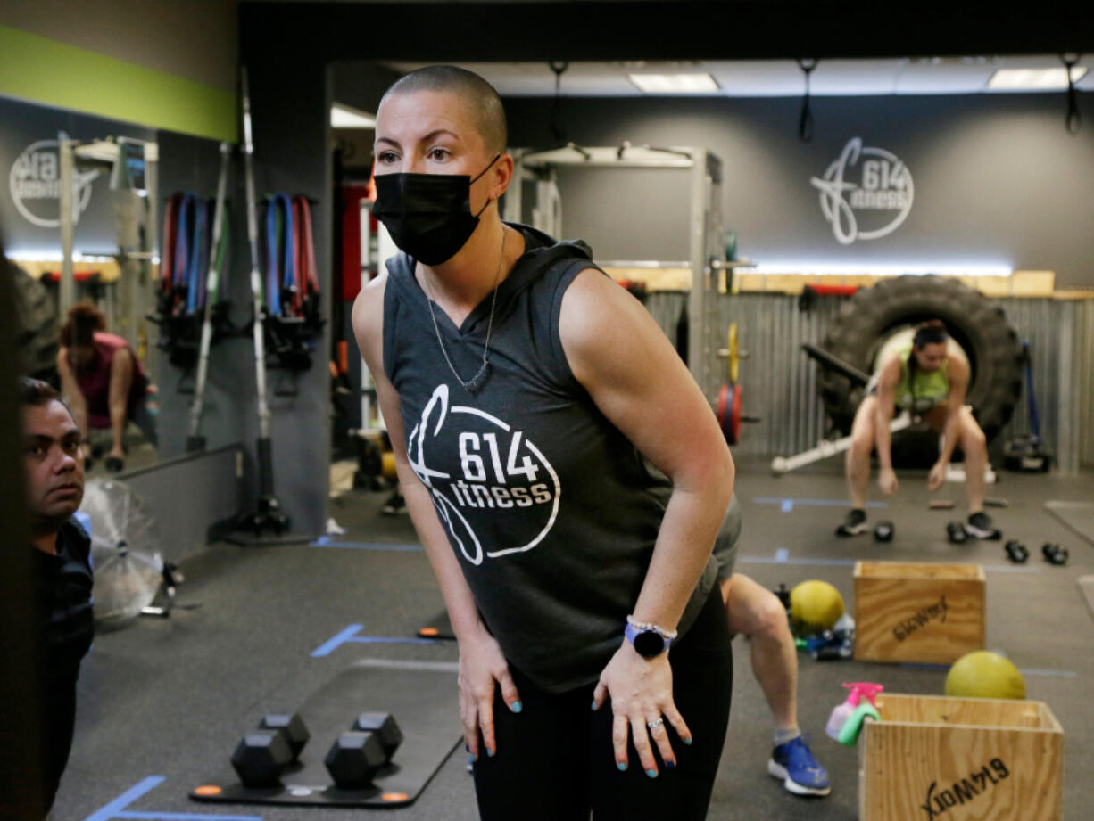 Personal trainer Jill Will keeps an eye on her students, who attend both in-person and virtually at 614Fitness in Columbus, Ohio, where trainers are equipped to teach a class virtually while also leading a group inside the facility. (Barbara J.