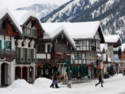 Scattered tourists cross Front Street Monday, Jan. 10, 2022, in Leavenworth, Washington. Feet of snow buried the town after a winter storm roared through the state, closing all four main mountain passes.