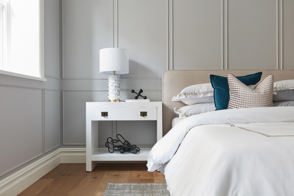 Pure white bedding with a camel detail is paired with a bed of a similar color for a calming vibe.