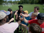 Boys huddle after playing soccer in 2019 during a weeklong camp in Pennsylvania for children grieving the loss of a parent, sibling or caregiver. During the pandemic, more than 167,000 children have lost a parent or caregiver to COVID-19.