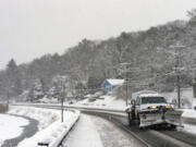 A plow drives down a recently plowed road by Birch Pond in Saugus, Massachusetts, on Jan. 7, 2022. Areas of New England received up to 12 inches of snow while many received 4 to 6 inches.