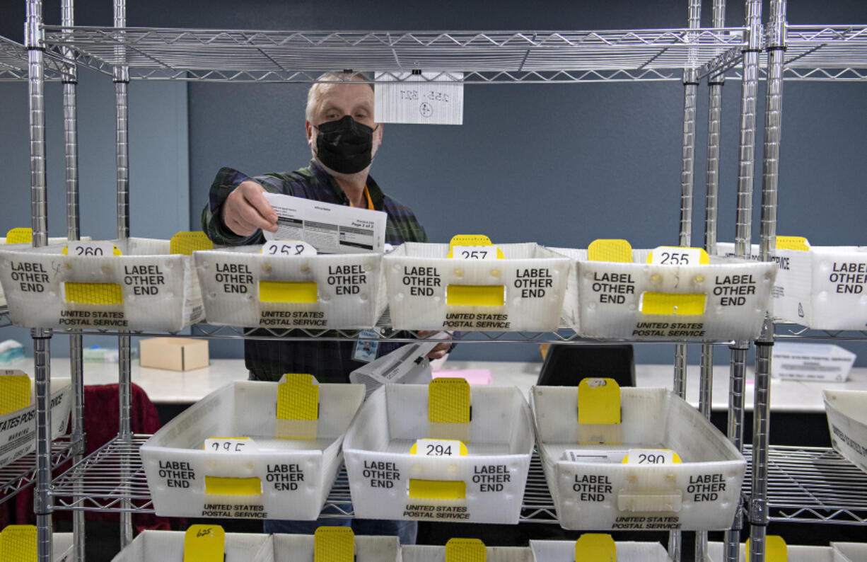 Election board worker Chuck Perine prepares ballots to be recounted by precinct while lending a hand to the recount of two tight races at the Clark County Elections Office on  Nov. 29.