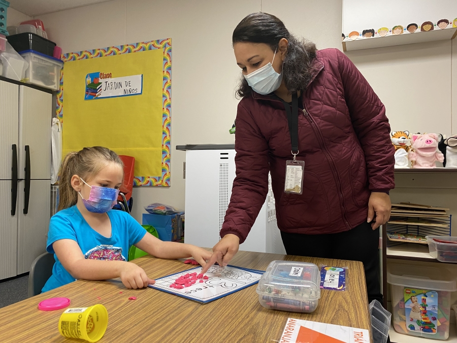 Washougal School District dual language program teacher Veronica Paredes (right) assists Hathaway Elementary School student Oakley Brush with an assignment in October 2021. Paredes, a former paraducator, earned a teaching certificate through the Educational Service District 112's ESD-U program.