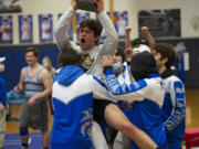 La Center's Austin Mattson is hoisted as he holds the SpudCat Trophy, awarded to the winner of  the Ridgefield-La Center wrestling match. La Center beat Ridgefield 35-30 on Thursday night at La Center on a pin by Leah Wallway at 106 pounds.