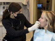 Dentist Rana Stino, left, checks the retainer fit on Holly Brown on Jan. 20 at Water Tower Dental Care in Chicago. Brown wears a retainer to protect her teeth from grinding.