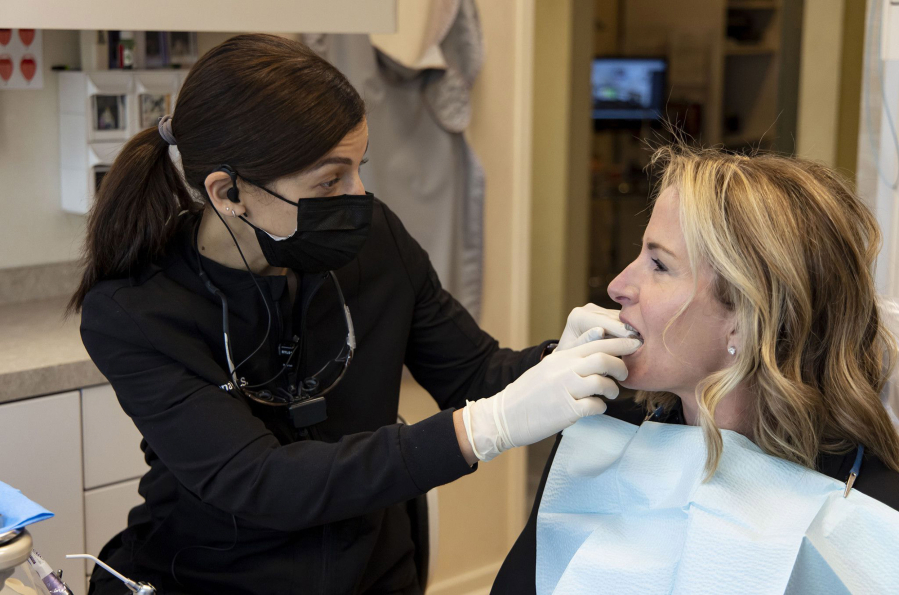 Dentist Rana Stino, left, checks the retainer fit on Holly Brown on Jan. 20 at Water Tower Dental Care in Chicago. Brown wears a retainer to protect her teeth from grinding.