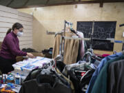 Volunteer Jill Karmy sorts through donated school supplies Monday afternoon while helping at the clothing pop-up shop for Afghan refugees at Friends of the Carpenter.