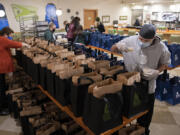 Chef Ricardo Gonzalez of The Diner, right, helps distribute the food into bags for Savor the Couve customers. The event has featured food from 35 restaurants so far this year.