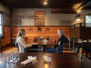 Devin McFeron of Desert Society, left, chats with Emma Fraser of Farrar's Bistro inside Farrar's Bistro in Felida. Both business owners are just in their 20s, and they encourage other young adults to take a chance on their career dreams.