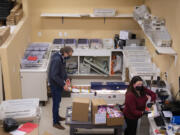 Larry Witzel, founder and president of SermonView, joins mailhouse technician Hannah Gill as they prepare invitations to be mailed from their Vancouver office. SermonView was among those impacted by the early end of a federal aid program to pandemic-hit businesses.