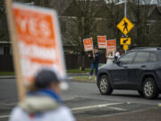 Supporters of the Ridgefield schools bond wave signs Friday at the intersection of Pioneer Street and Royle Road in Ridgefield. Ballots for the upcoming Feb. 8 special election were sent to voters Friday.