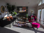 Afternoon light illuminates the colorful furniture and artwork in a "maximalist lite" living room in southeast Vancouver, designed by Brandi Oldham for Sarah and Ian Williams.