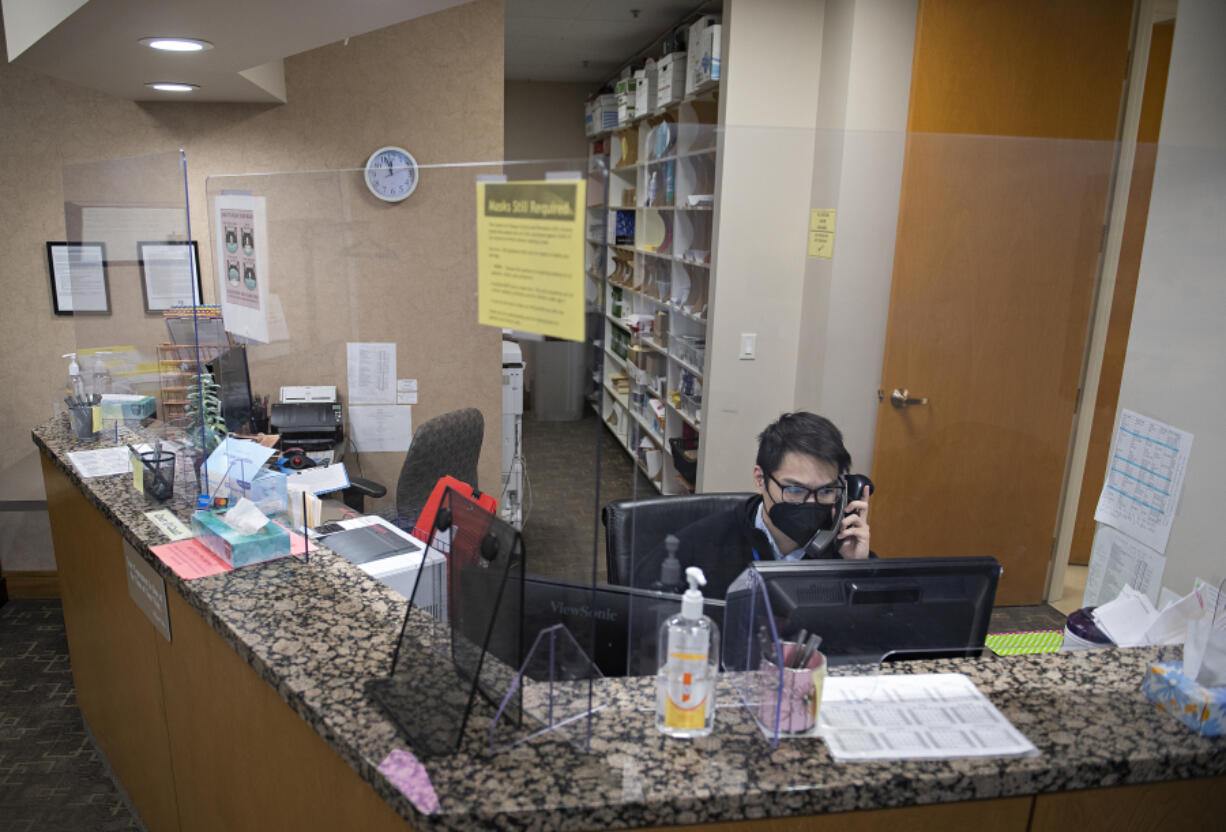 Sam Sugarman, patient service representative for Northwest Medical Associates-Praxis Health, takes a call while working at the front desk on Thursday afternoon. Praxis Health, Oregon's largest independent medical group, has expanded into Vancouver after recently acquiring Northwest Medical Associates, a 35-year-old clinic in east Vancouver.