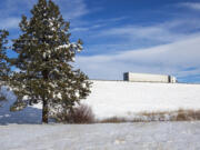 A semitruck takes an exit off Interstate 90 in Ellensburg, Wash., Friday, Jan. 7, 2022. As of Friday, both Snoqualmie and Blewett passes were expected to be closed through Sunday due to heavy snow in the area.