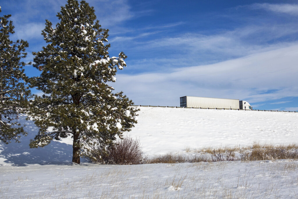 A semitruck takes an exit off Interstate 90 in Ellensburg, Wash., Friday, Jan. 7, 2022. As of Friday, both Snoqualmie and Blewett passes were expected to be closed through Sunday due to heavy snow in the area.