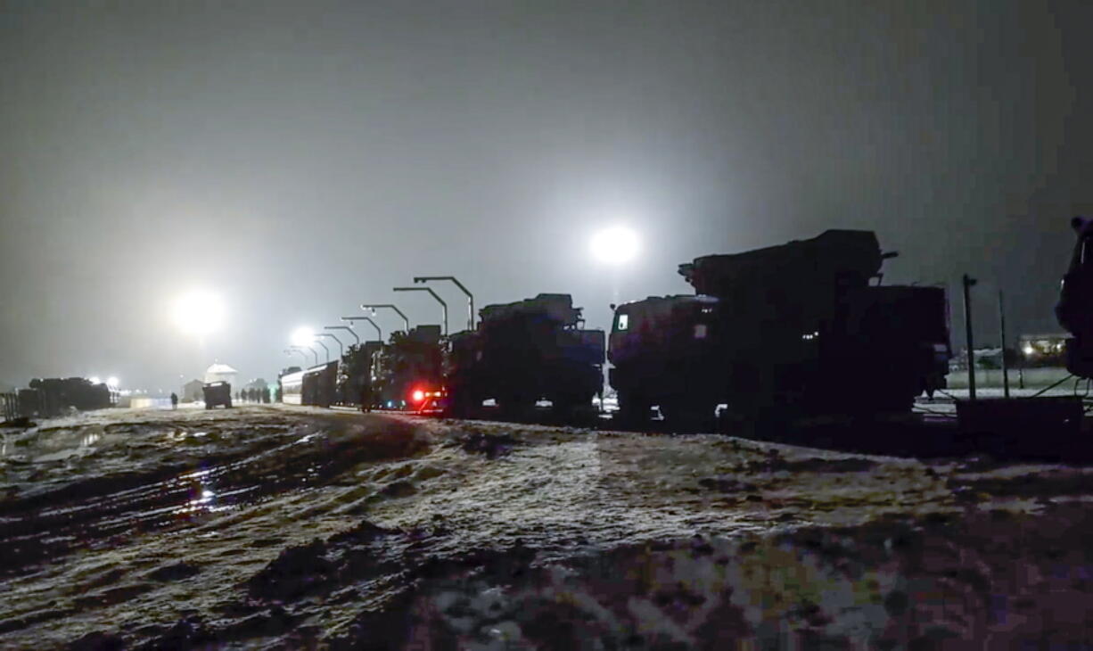 In this photo taken from video provided by the Russian Defense Ministry Press Service on Saturday, Jan. 29, 2022, Russian military vehicles prepares to drive off a railway platforms after arrival in Belarus. In a move that further beefs up forces near Ukraine, Russia has sent an unspecified number of troops from the country's far east to its ally Belarus, which shares a border with Ukraine, for major war games next month.