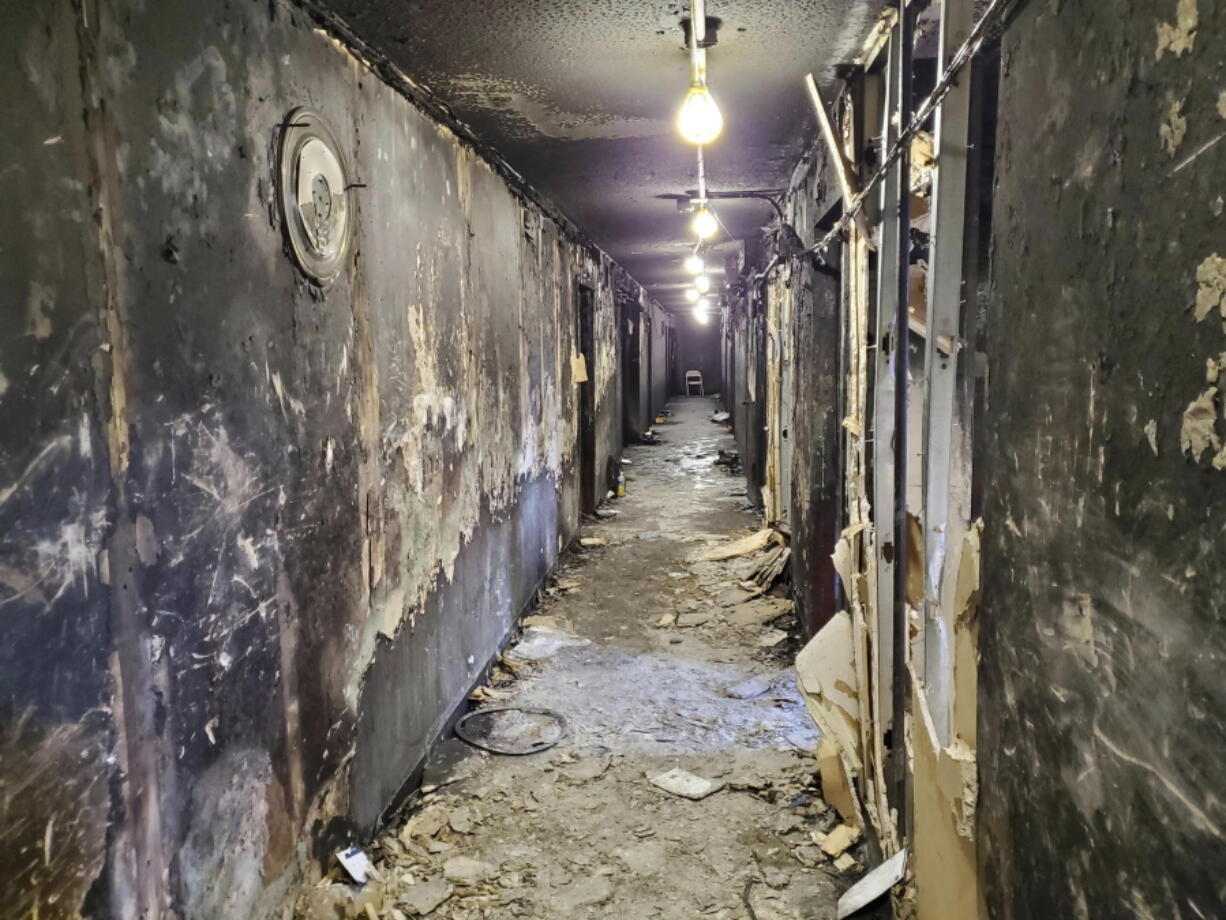 This photo provided by the NYC Department of Buildings on Wednesday, Jan. 12, 2022, shows charred walls and debris in a third-floor hallway at the Bronx apartment building which suffered a fatal fire on Sunday, in New York. The fire damaged only a small part of the 19-story building, but victims succumbed to smoke pouring through the building through an open door. (Ryan J.