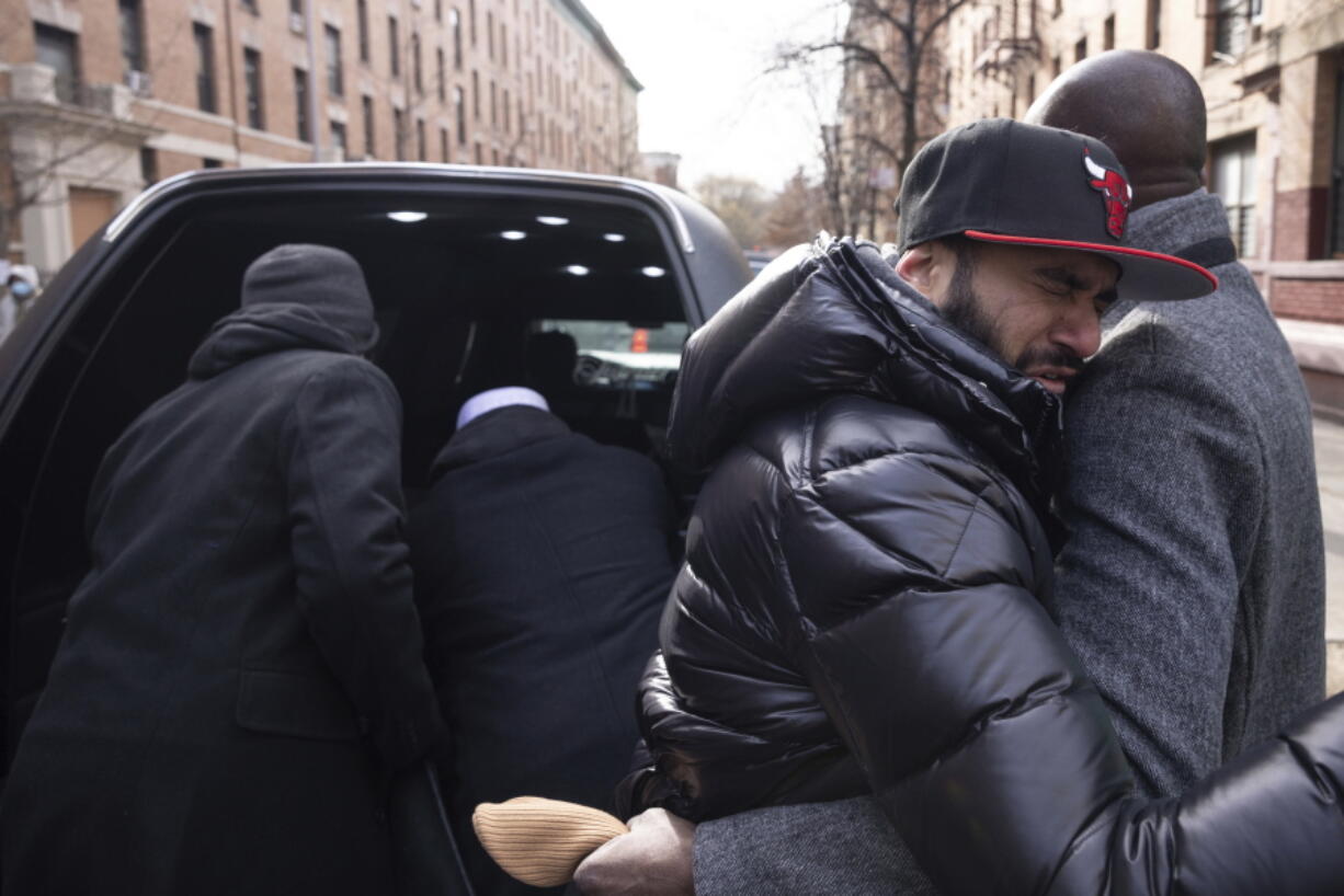 A person hugs the father of Ousmane Konteh, 2, in front of a hearse after the funeral service for victims from the apartment building which suffered the city's deadliest fire in three decades, at the Islamic Cultural Center for the Bronx on Sunday, Jan. 16, 2022, in New York.