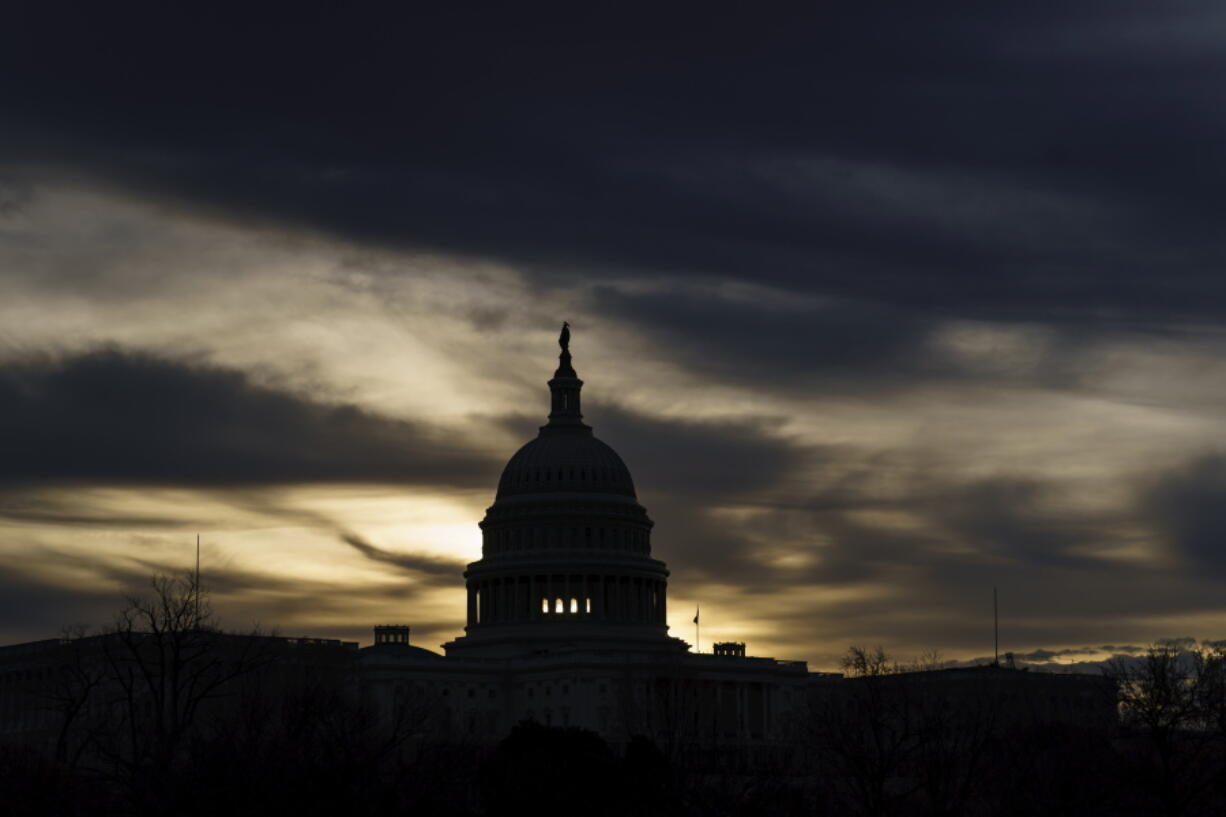 FILE - The U.S. Capitol is seen in Washington, early Dec. 17, 2021. President Joe Biden faces a steep path to achieve his ambitious goal to slash planet-warming greenhouse gas emissions in half by 2030, as a $2 trillion package of social and environmental initiatives remains stalled.  Biden's Build Back Better plan, which contains $550 billion in spending and tax credits aimed at promoting clean energy, was sidetracked by Democratic Sen. Joe Manchin, who said just before Christmas that he could not support the legislation as written. (AP Photo/J.