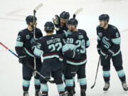 Seattle Kraken defenseman Vince Dunn (29) is greeted by teammates after he scored a goal against the Chicago Blackhawks during the second period of an NHL hockey game, Monday, Jan. 17, 2022, in Seattle. (AP Photo/Ted S.