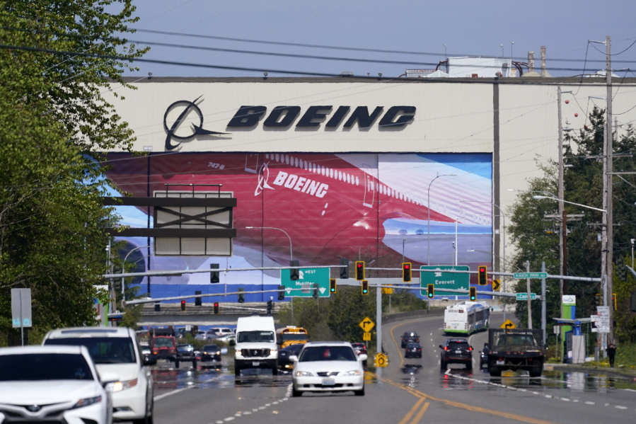 Traffic drives in view of a massive Boeing Co. production plant, where images of jets decorate the hangar doors, Friday, April 23, 2021, in Everett, Wash. .