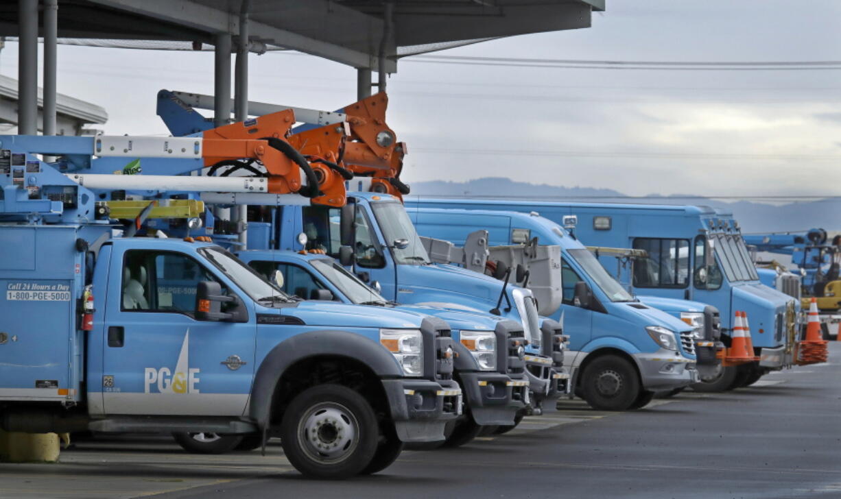 FILE - In this Jan. 14, 2019, file photo, Pacific Gas & Electric vehicles are parked at the PG&E Oakland Service Center in Oakland, Calif. Pacific Gas & Electric power lines sparked last summer's Dixie Fire in Northern California that swept through five counties and burned more than 1,300 homes and other buildings, state fire officials said Tuesday, Jan. 4, 2022.