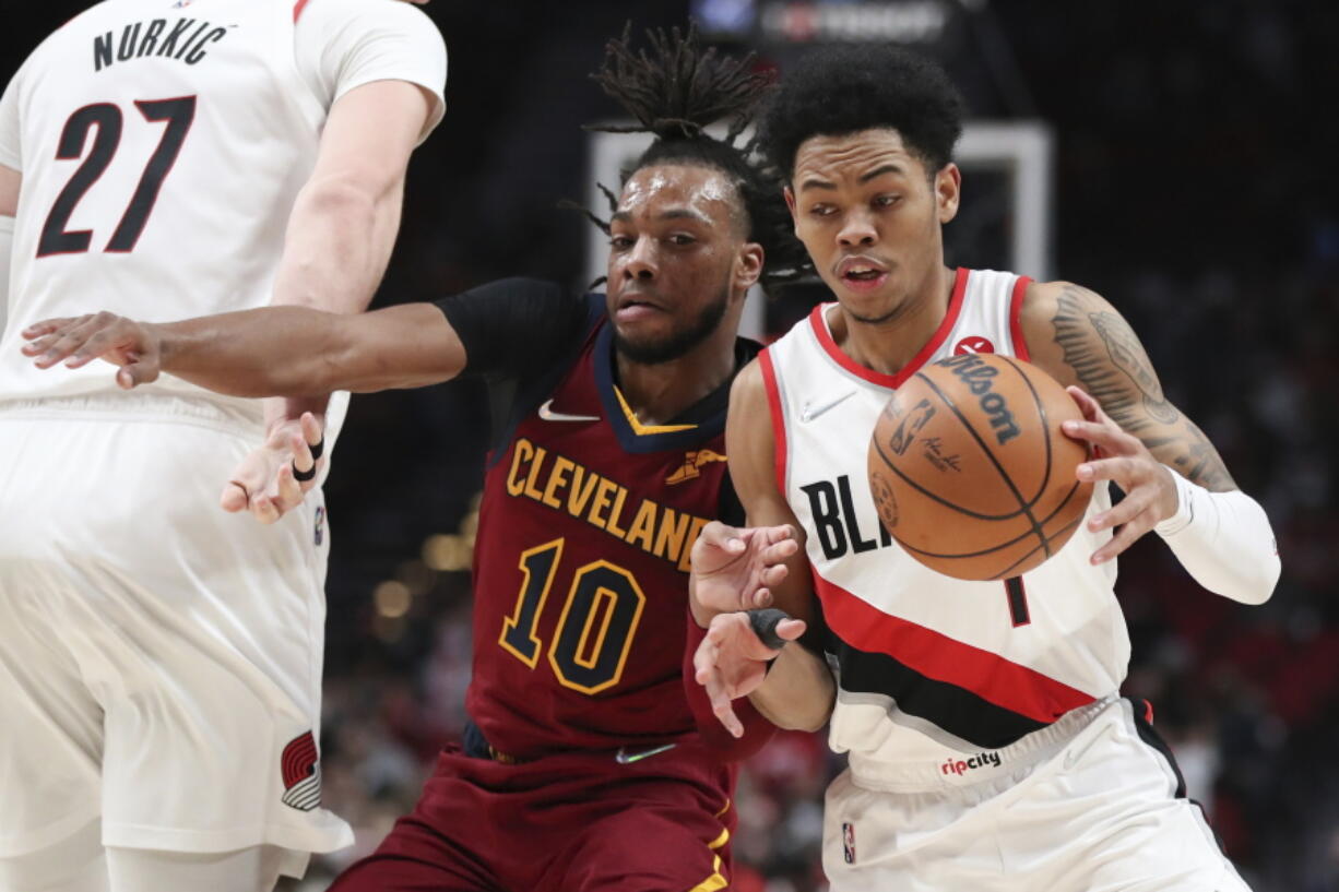 Cleveland Cavaliers guard Darius Garland defends against Portland Trail Blazers guard Anfernee Simons, right, during the first half of an NBA basketball game in Portland, Ore., Friday, Jan. 7, 2022.