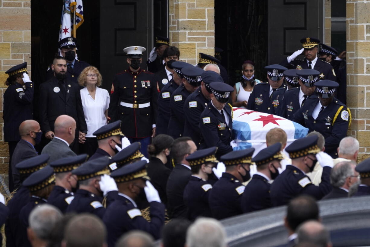 FILE - Elizabeth French, in white, and her son Andrew, left, follow the casket of her daughter, Chicago police officer Ella French, after a funeral service at the St. Rita of Cascia Shrine Chapel Thursday, Aug. 19, 2021, in Chicago. French was killed and her partner was seriously wounded during an Aug. 7 traffic stop on the city's South Side. The year 2021 ended as one of the deadliest on record in recent years in Chicago, according to statistics released by the city's police department on Saturday, Jan. 1, 2022.