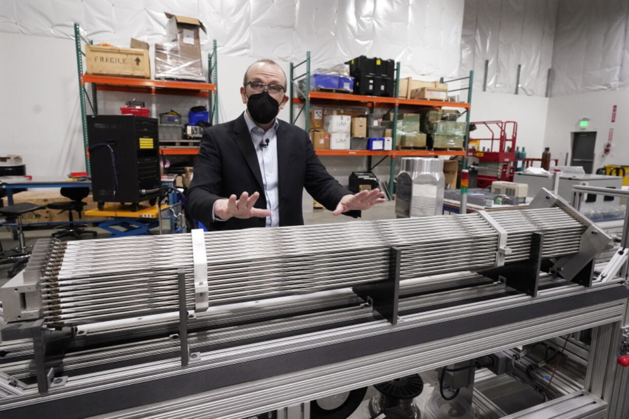 Chris Levesque, president and CEO of TerraPower, a company developing and building small nuclear reactors, displays a fuel assembly model, Thursday, Jan. 13, 2022, in Everett, Wash. The 5-foot model is about one-third actual length and would be vertical when in use, rather than horizontal. By cooling the reactor with liquid sodium, a metal that solidifies at well above room temperature, TerraPower says its relatively small, 345-megawatt plant will be safe and less expensive than conventional, water-cooled nuclear plants.