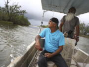 Donald Dardar, left, and Russell Dardar look toward the eroding shoreline of Bayou Pointe-au-Chien in southern Louisiana on Wednesday, Sept. 29, 2021. The brothers have lived along the bayou all their lives as shrimpers and fishermen. They now also work to preserve the coastal land from further erosion by refilling canals and developing living shorelines.