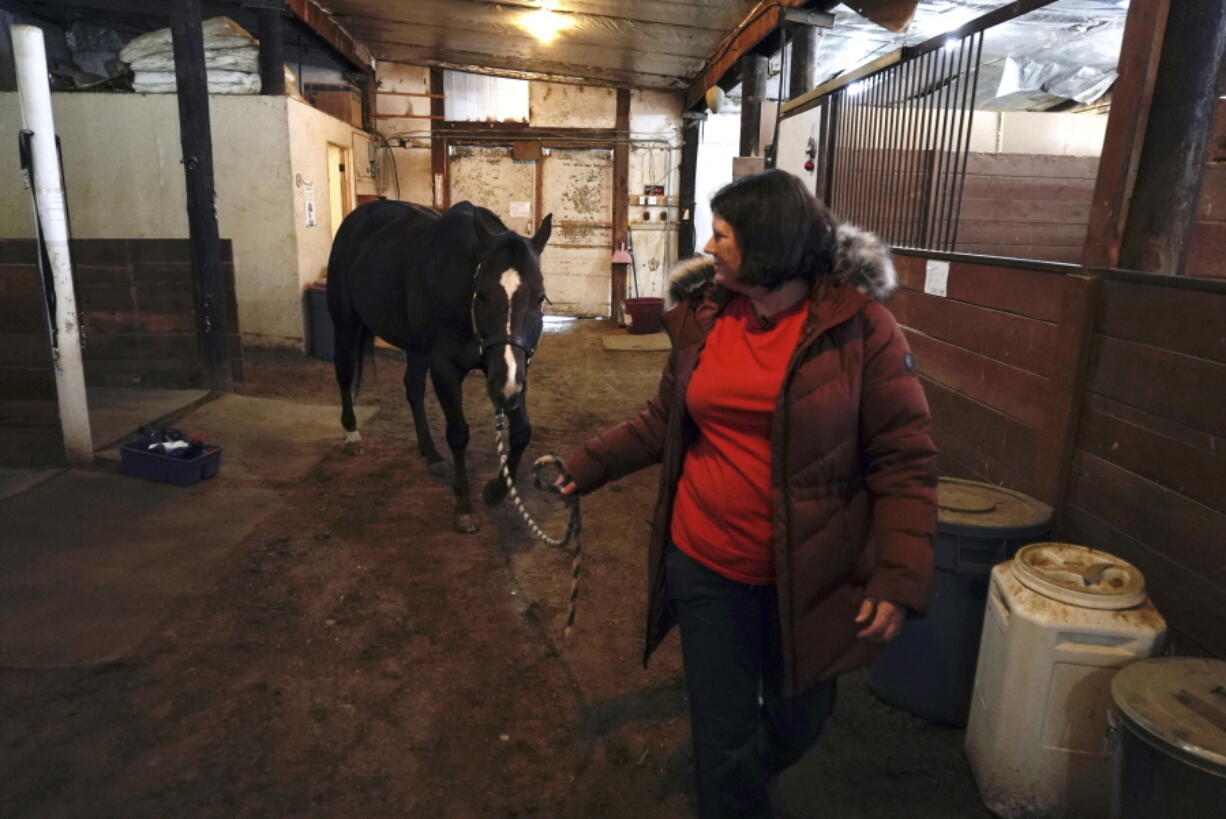 Lisa Young walks her horse, Foxy, Wednesday, Jan. 5, 2022, in Golden, Colo. She lost her home in the grass fires that hit Boulder County last week, and likely lost her two cats as well. Taking care of her horse gives her some semblance of normalcy, she said.