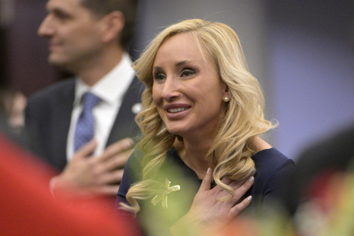 Florida Sen. Lauren Book stands for the Pledge of Allegiance during a legislative session, Tuesday, Jan. 11, 2022, in Tallahassee, Fla.  Book says she was extorted by someone threatening to reveal nude photos that were stolen from her. She's sponsoring a bill making it a felony to steal sexually explicit images from digital devices. (AP Photo/Phelan M.