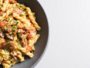 This image released by Milk Street shows a recipe for Gemelli w/Tomatoes, Salami and Fontina.