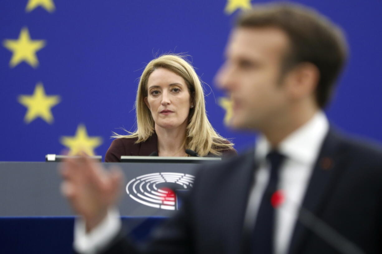 Newly elected President of the European Parliament Roberta Metsola of Malta, left, listens to the speech of French President Emmanuel Macron, at the European Parliament Wednesday, Jan. 19, 2022 in Strasbourg, eastern France.