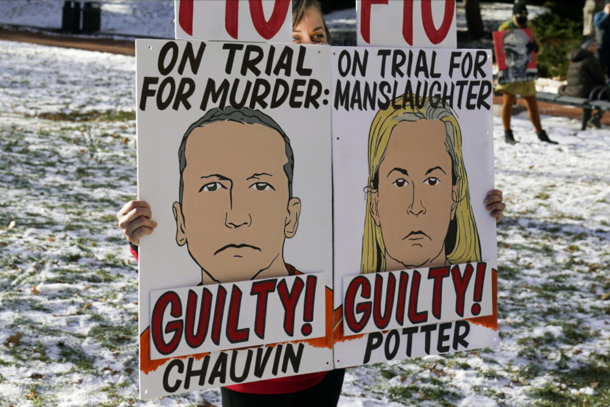 FILE - A demonstrator holds up "GUILTY" signs at the Hennepin County Government Center, Dec. 23, 2021, in Minneapolis, where jurors found former suburban Minneapolis police officer Kim Potter guilty of first degree and second degree manslaughter in the death of motorist Daunte Wright during a traffic stop. Data show it's rare for police officers to be convicted of on-duty killings. But three recent convictions of police officers in Minnesota have some people wondering whether that's changing.