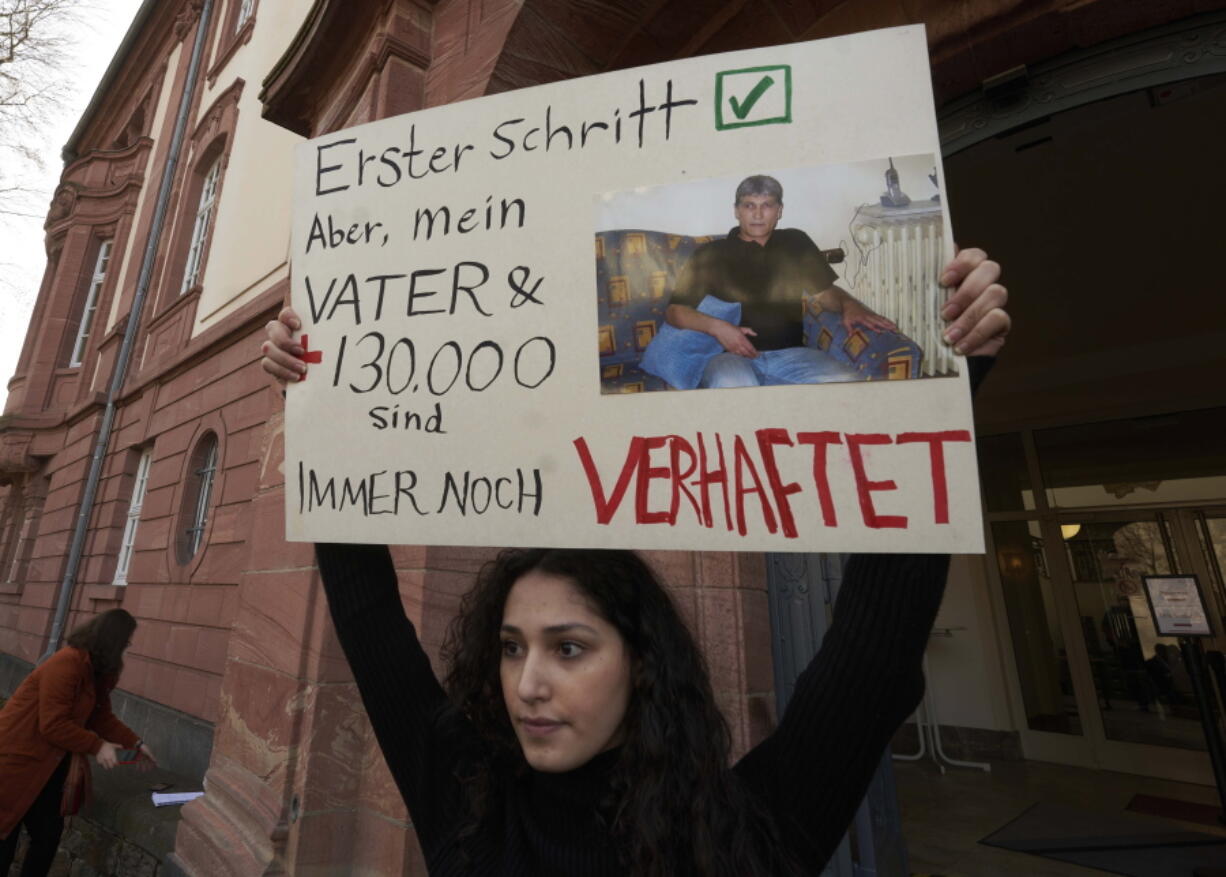 FILE - Serda Alshehabi comments on the verdict in front of the building of the Higher Regional Court in Koblenz, Germany, Feb. 24, 2021. The court in the German city of Koblenz is scheduled to deliver its ruling Thursday in the trial of Anwar Raslan, a former Syrian secret police officer who is accused of crimes against humanity for overseeing the abuse of detainees at a jail near Damascus a decade ago.Victims of torture in Syria and human rights activists say they hope the upcoming verdict in a landmark trial will be a first step toward justice for countless Syrians who suffered abuse at the hands of President Bashar Assad's government in the country's long-running conflict.