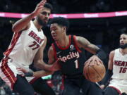 Portland Trail Blazers guard Anfernee Simons drives past Miami Heat center Omer Yurtseven during the first half of an NBA basketball game in Portland, Ore., Wednesday, Jan. 5, 2022.