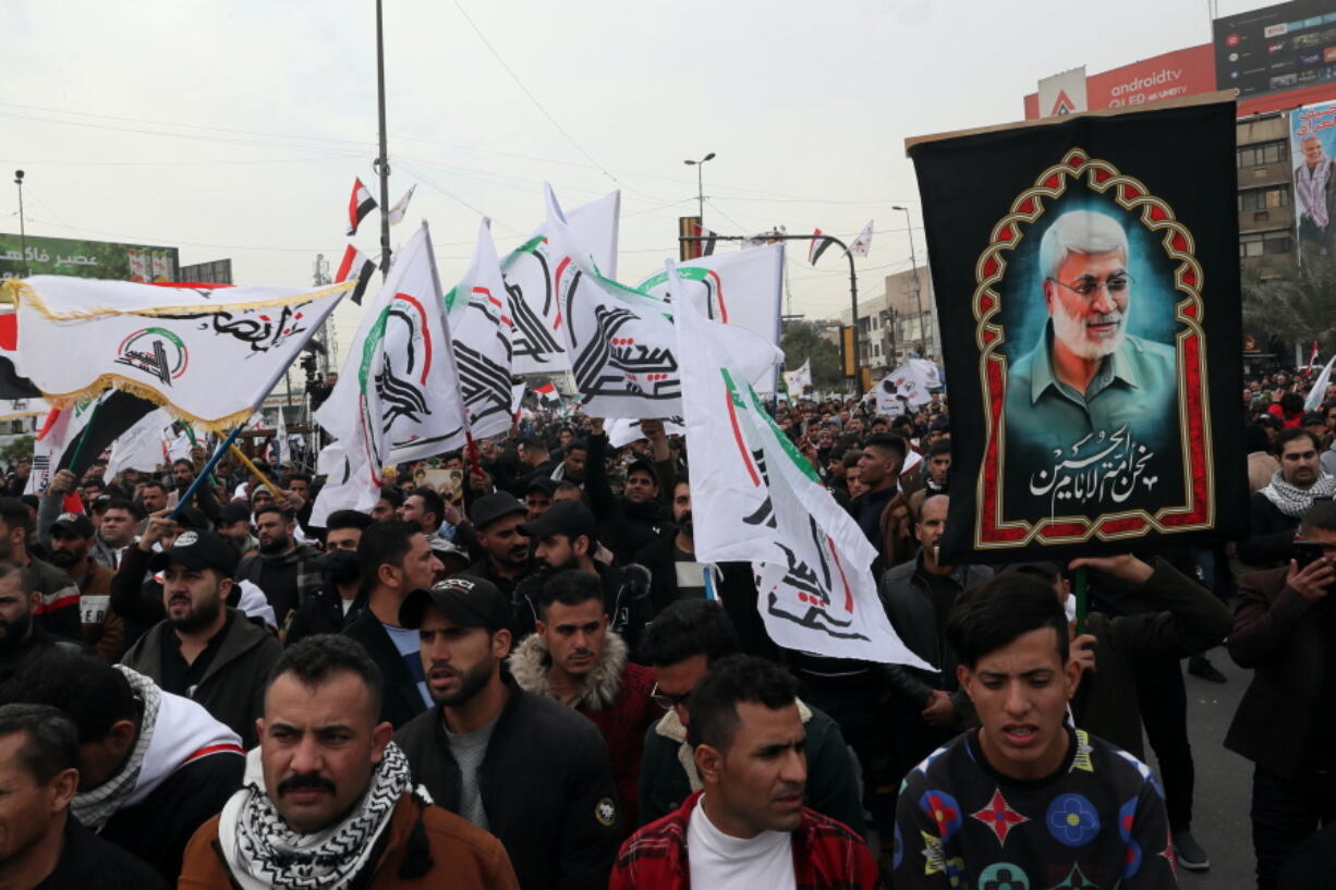 Supporters and members of the Popular Mobilization Forces chant slogans in Baghdad, Iraq, Saturday, Jan. 1, 2022. Hundreds rally in Baghdad on Soleimani assassination anniversary, chanting anti-American slogans, hundreds of people rallied in in the Iraqi capital on the first day of the year Saturday to mark the anniversary of the killing of a powerful Iranian general and a top Iraqi militia leader in a U.S. drone strike.