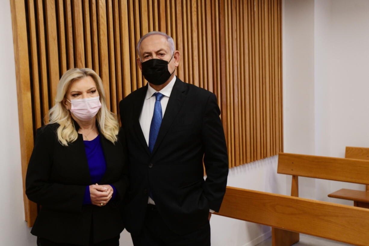 Former Israeli Prime Minister Benjamin Netanyahu and his wife Sarah, stand in the Tel Aviv Magistrate's Court Monday, Jan. 10, 2022, during a preliminary hearing in a defamation lawsuit. Former Prime Minister Benjamin Netanyahu, his wife and son appeared in the Tel Aviv Magistrate's court Monday for the opening of their case against Olmert, Netanyahu's predecessor as Israel's prime minister. The Netanyahus are suing Olmert for saying they suffered from "mental illness" during an interview last year.