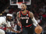 Portland Trail Blazers guard Damian Lillard dribbles past Utah Jazz guard Mike Conley during the second half of an NBA basketball game in Portland, Ore., Wednesday, Dec. 29, 2021. The Jazz won 120-105.