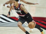 Portland Trail Blazers guard Anfernee Simons (1) drives to the basket in front of Sacramento Kings guard De'Aaron Fox during the second half of an NBA basketball game in Portland, Ore., Sunday, Jan. 9, 2022.