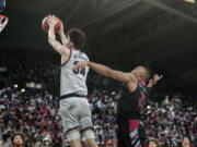 Gonzaga center Chet Holmgren, left, goes up for a dunk in front of Loyola Marymount guard Cam Shelton during the first half of an NCAA college basketball game, Thursday, Jan. 27, 2022, in Spokane, Wash.