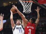 Dallas Mavericks guard Luka Doncic is fouled by Portland Trail Blazers guard CJ McCollum during the first half of an NBA basketball game in Portland, Ore., Wednesday, Jan. 26, 2022.