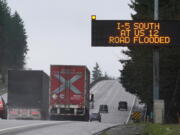 A sign warns drivers of a section of Interstate 5 that is closed ahead due to rising flood water from the Chehalis River, Friday, Jan. 7, 2022, near Rochester, Wash. Rain and snow continued to fall across the Pacific Northwest Friday, causing flooding and concerns about avalanche danger in the mountains. (AP Photo/Ted S.